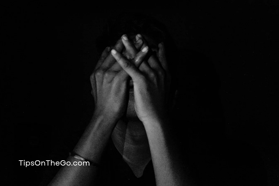 a black and white photo of a person covering their face
