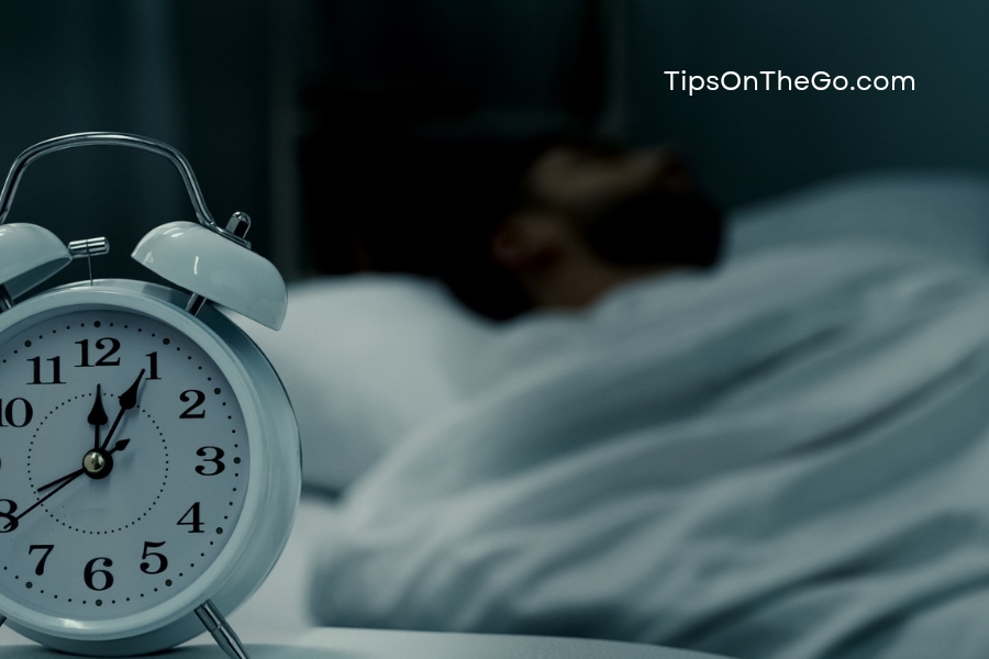 an alarm clock on a bed in a dark room
