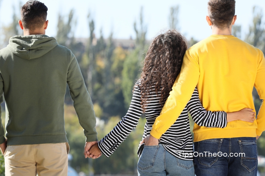 Three people holding hands and walking along a path