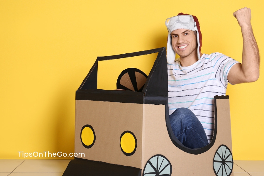 a person is sitting in a cardboard car